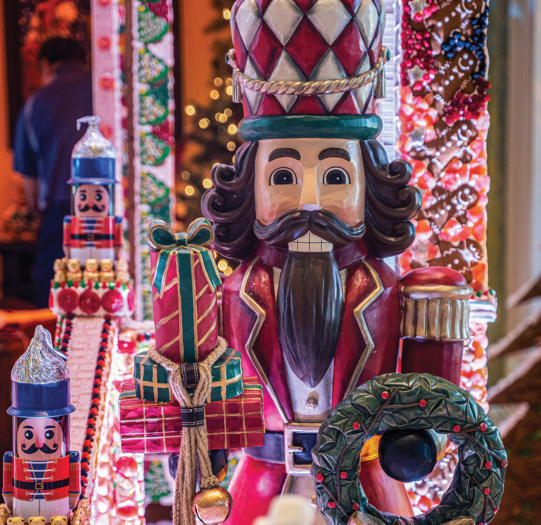 Nutcracker on display next to the gingerbread house