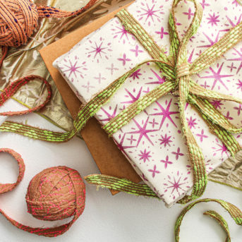Gift wrap with pink stars and a ribbon wrapped around it