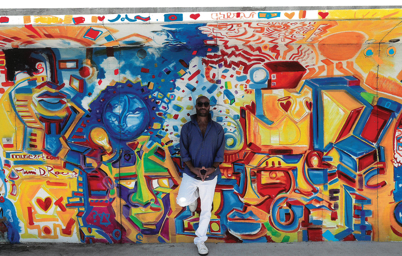 Artist Marvin Rouse standing in front of his artworkk