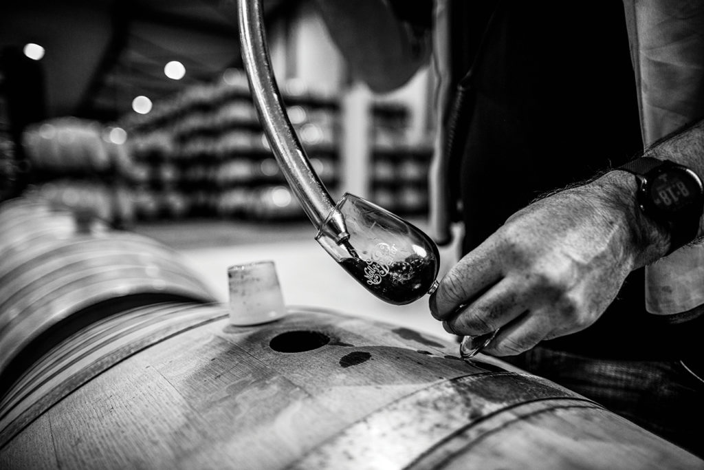 Collecting wine from barrel