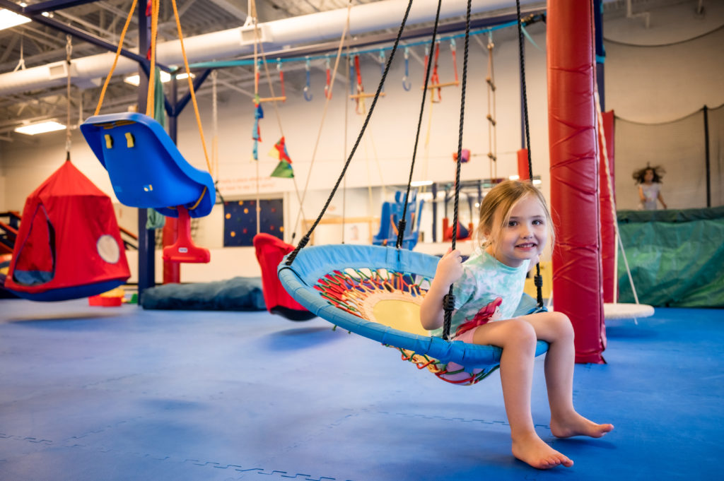 Child on swing at WeRockTheSpectrum The 5,300-square-foot We Rock the Spectrum a sensory-safe space for children