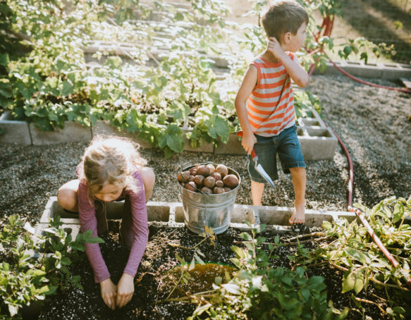 Two small kids gardening outdoors