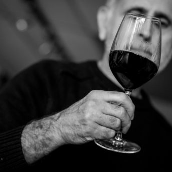Black and white photo of Peter Rizzo and wine glass