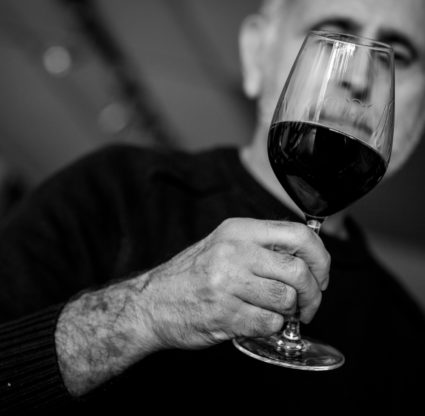 Black and white photo of Peter Rizzo and wine glass